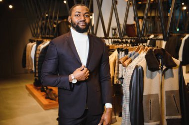 Klasik erkek giyim mağazasında çalışan şık giyinmiş Afro-Amerikan bir adam..