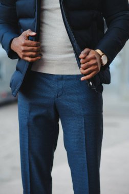 Sokakta yeni şık kıyafetler giymiş Afro-Amerikalı bir adam.