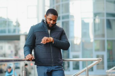 Sokakta yeni şık kıyafetler giymiş Afro-Amerikalı bir adam.