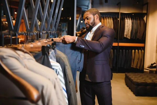 African American man, clothing store, chooses clothes