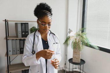 Siyah Afrikalı kadın doktor kullanmadan önce test enjeksiyonu kullanıyor.