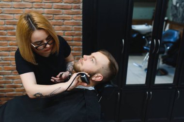 Berber dükkanında sakal tıraşı olan bir müşteri.