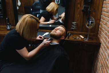 Berber dükkanında sakal tıraşı olan bir müşteri.