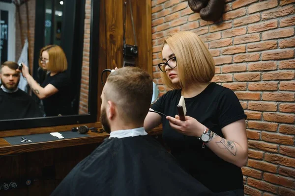 Barber Woman Cutting Man Hair at the Barbershop. Woman Working as a Hairdresser. Small Business Concept.