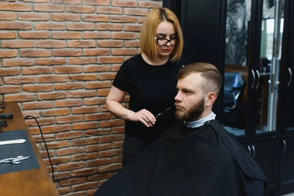 Barber Woman Cutting Man Hair at the Barbershop. Woman Working as a Hairdresser. Small Business Concept.