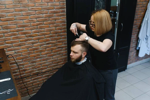 Barber Woman Cutting Man Hair at the Barbershop. Woman Working as a Hairdresser. Small Business Concept.