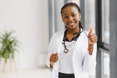 Güzel Afro-Amerikan hemşire kollarını kavuşturdu.