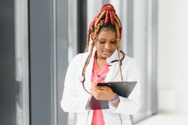 Güzel Afro-Amerikan hemşire kollarını kavuşturdu.