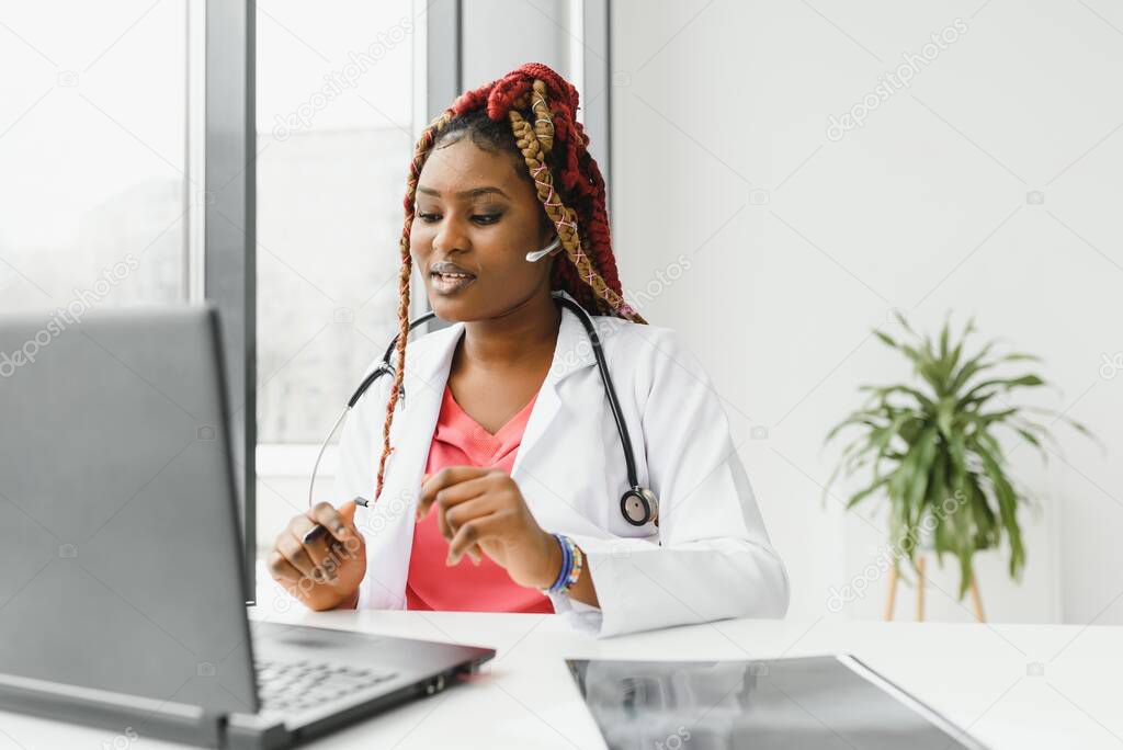 Pretty young smart female doctor or therapist giving health care advice online by webcam videochat and consulting distant patient. Remote medical services. Telemedicine.