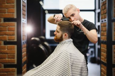 Yakın plan, usta kuaför makas ve tarak ile saç stili ve stili yapıyor. Berber Dükkanı.
