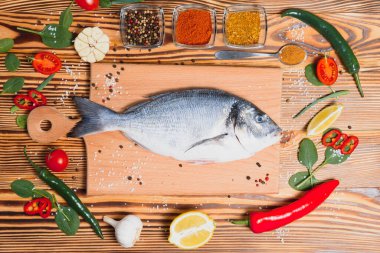 Çiğ balık pişirme ve malzemeler. Dorado, limon, otlar ve baharatlar. Masada kopyalama alanı olan üst görünüm