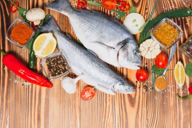 Çiğ dorado ve baharatlı alabalık kesim tahtasında pişiyor. Taze balık dorado.