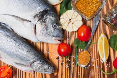 Çiğ dorado ve baharatlı alabalık kesim tahtasında pişiyor. Taze balık dorado.