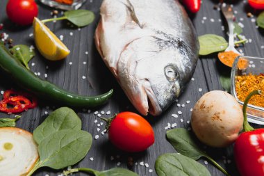 Çiğ balık pişirme ve malzemeler. Dorado, limon, otlar ve baharatlar. Masada kopyalama alanı olan üst görünüm