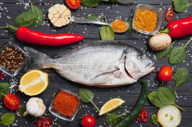 Çiğ balık pişirme ve malzemeler. Dorado, limon, otlar ve baharatlar. Masada kopyalama alanı olan üst görünüm