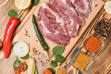 Taze sebzeli çiğ et ve ahşap arka planda baharatlar. Üst Manzara. Metin için boş alan. Kendini hazırla.