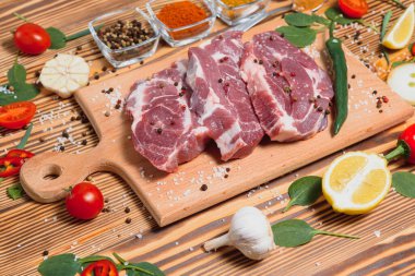 Çiğ domuz pirzolası mutfakta sebze ve baharatla birlikte yemek ve yemek pişirme konseptini hazırlayın..