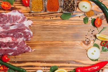 Mutfak masasındaki ahşap kesme tahtasında çiğ domuz eti. Biftek pişirmek için. Kavrulmuş ya da baharatla kızartılmış.