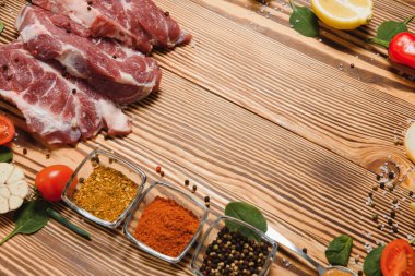 Mutfak masasındaki ahşap kesme tahtasında çiğ domuz eti. Biftek pişirmek için. Kavrulmuş ya da baharatla kızartılmış.