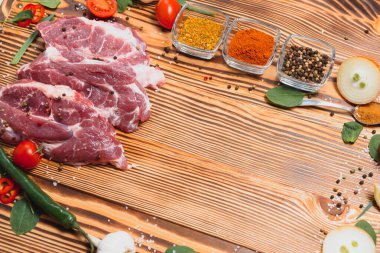 Çiğ domuz pirzolası mutfakta sebze ve baharatla birlikte yemek ve yemek pişirme konseptini hazırlayın..