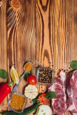 Mutfak masasındaki ahşap kesme tahtasında çiğ domuz eti. Biftek pişirmek için. Kavrulmuş ya da baharatla kızartılmış.