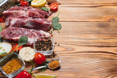 Mutfak masasındaki ahşap kesme tahtasında çiğ domuz eti. Biftek pişirmek için. Kavrulmuş ya da baharatla kızartılmış.