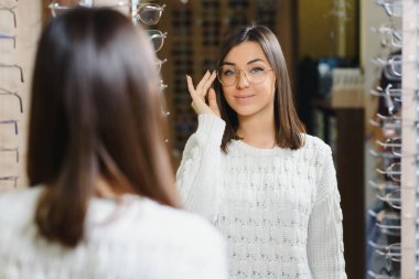 Optik Mağazasında Satılık Gözlük Kız Alışverişi. Çok şık bir müşteri indirimli gözlük alıyor.