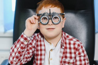 Dürbünlü lambayla oğlanın görme testi. Bir gencin gözünün retinasını yakından kontrol ediyorum. Oftalmoloji Kliniği