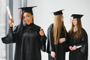 Eğitim teması: Akademik elbiseyle mezun olan kız.