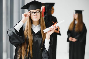 Mezuniyet töreninde sınıf arkadaşlarıyla güzel bir bayan üniversite mezunu.