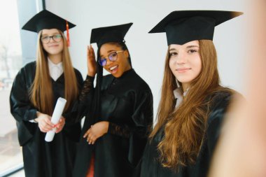 Mezuniyet töreninde sınıf arkadaşlarıyla güzel bir bayan üniversite mezunu.