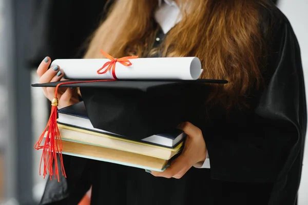 Diploma ve kitap tutan kız öğrenci.