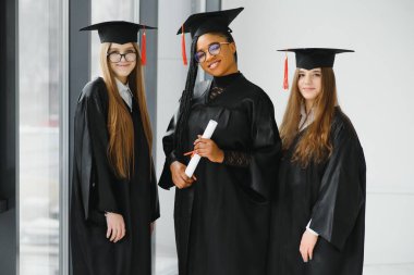 Diploma taşıyan çok ırklı mezunların portresi