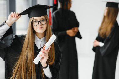 Eğitim teması: Akademik elbiseyle mezun olan kız.
