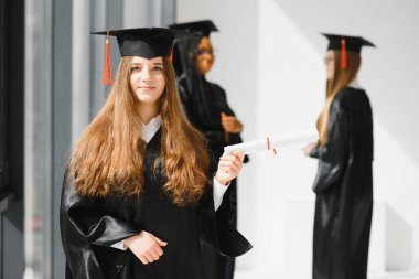 Eğitim teması: Akademik elbiseyle mezun olan kız.