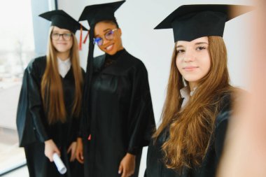 Diploma taşıyan çok ırklı mezunların portresi