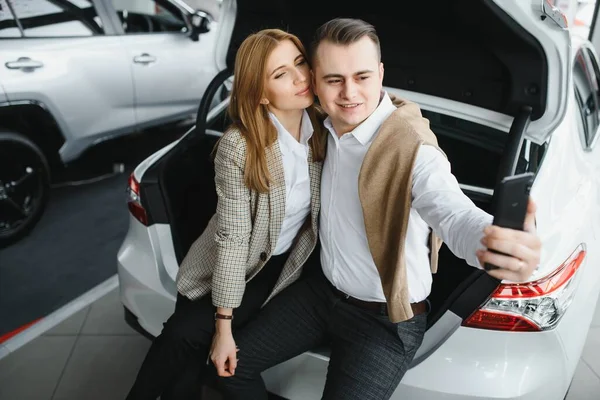 Young family making selfie in a car show room