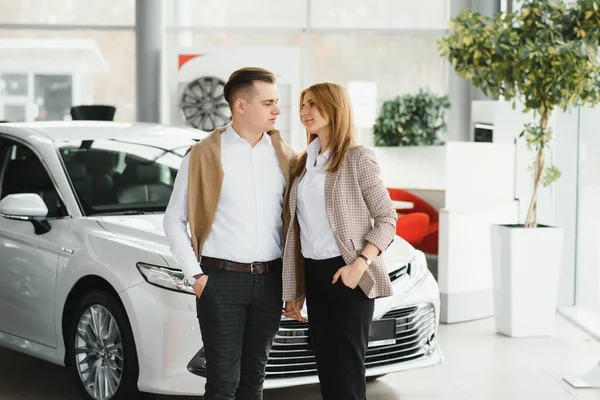 Young couple smiling at auto showroom