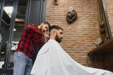 Ciddi Sakallı Genç Adam Berbere Saç Kestiriyor. Berber Dükkanı Teması