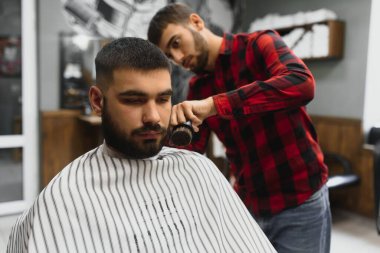 Ciddi Sakallı Genç Adam Berbere Saç Kestiriyor. Berber Dükkanı Teması