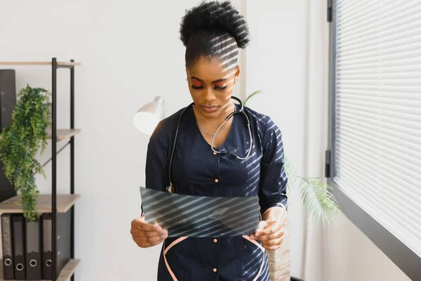 beautiful female african medical worker holding x-ray