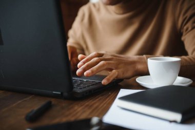 Kafede dizüstü bilgisayarı olan Afrikalı Amerikalı bir iş adamı.