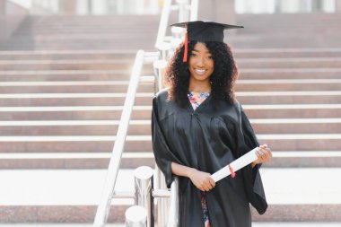 Neşeli Afro-Amerikan lisansüstü öğrencisi elinde diplomasıyla