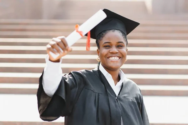 持有毕业文凭的年轻女非洲裔美国学生在户外摆姿势 — 图库照片