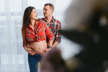 Çocuğu bekleyen genç çiftin portresi.