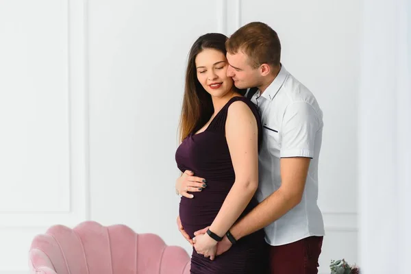 Hombre Cariñoso Abrazando Esposa Embarazada Por Detrás Pie Cerca Ventana —  Fotos de Stock