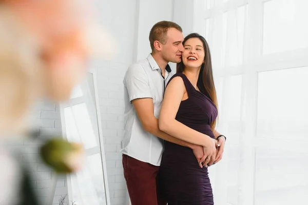 Amare Uomo Abbracciare Moglie Incinta Dietro Piedi Vicino Alla Finestra — Foto Stock