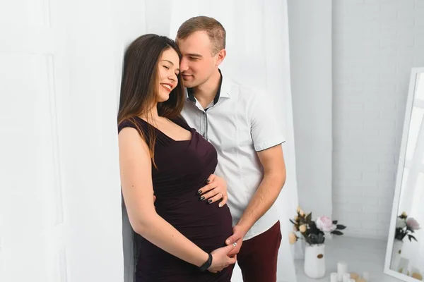 Liebender Mann Umarmt Seine Schwangere Frau Von Hinten Fenster Stehend — Stockfoto