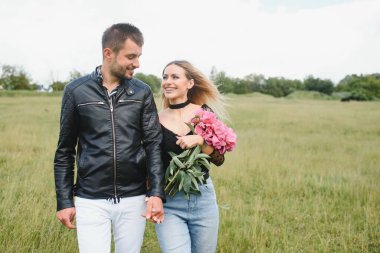 Genç çift bahar boyunca parkta yürür ve sarılırlar. Birlikte eğleniyoruz. Gençlik, aşk ve yaşam tarzı kavramı.