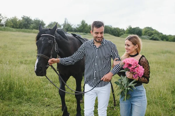 自然の中で楽しみを持つ愛のカップル 馬を持つ若いカップル — ストック写真